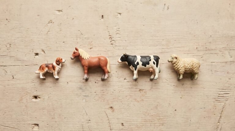 Miniaturas realistas de animais alinhadas sobre madeira clara